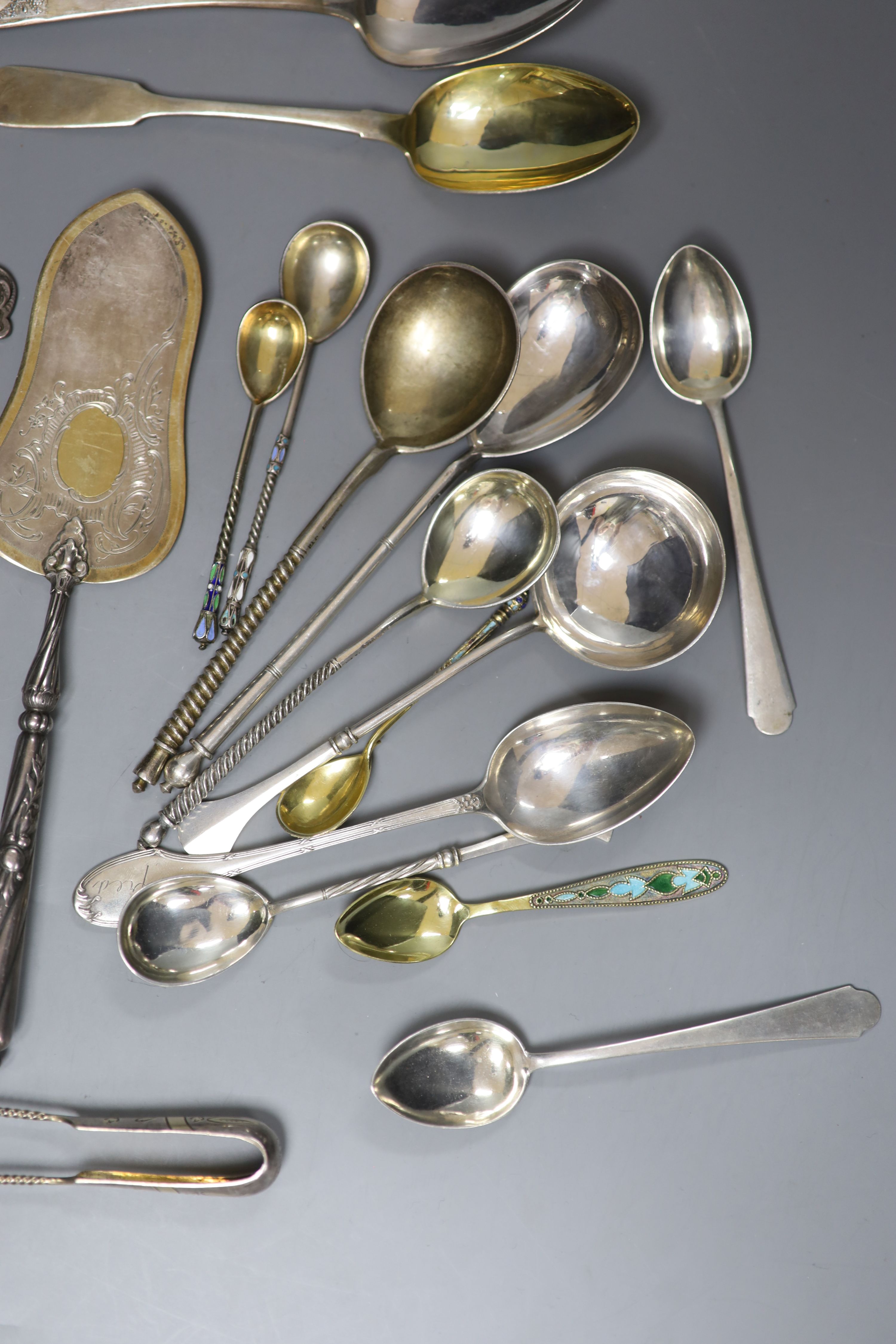 A late 19th century Russian 84 zolotnik tea strainer, a Russian cake slice and sugar sifter and a group of other Russian flatware including enamelled teaspoons